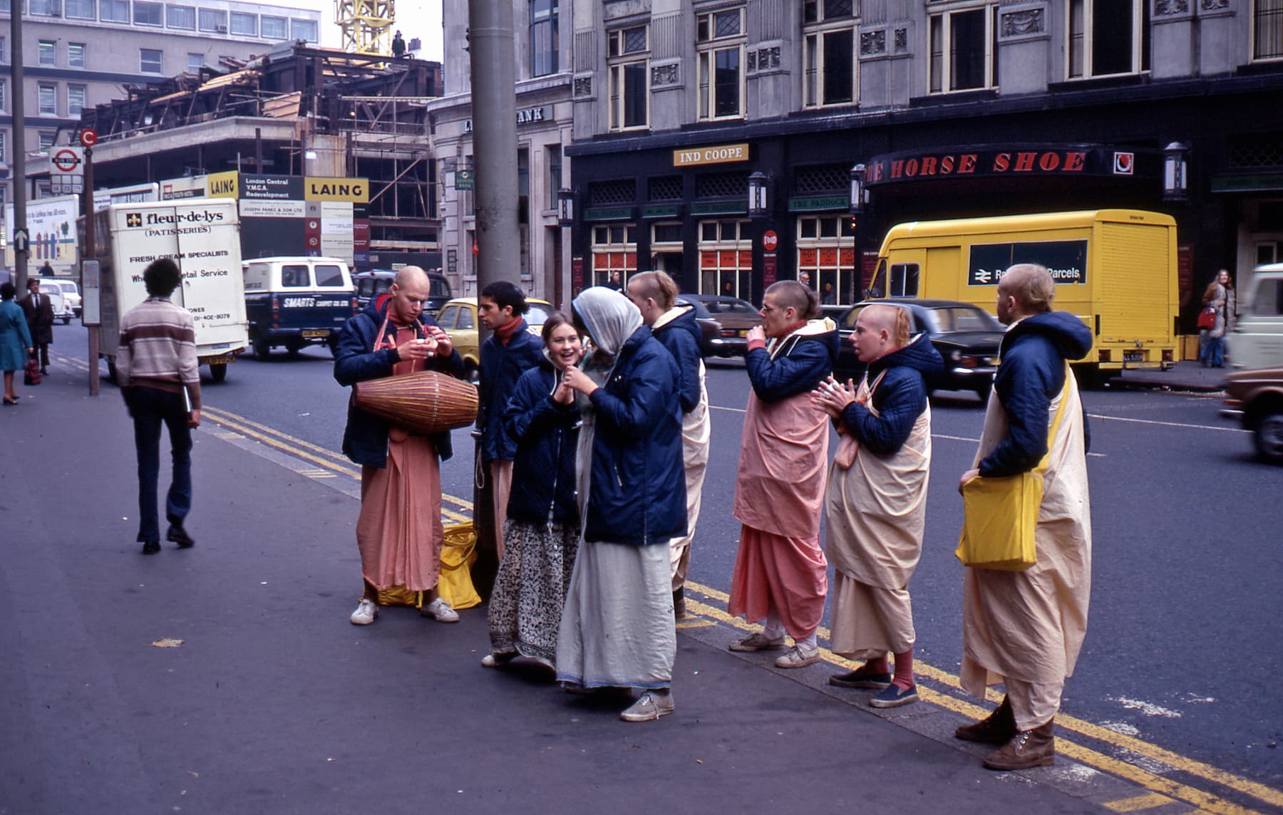 Membri del movimento Hare Krishna che cantano e suonano il tamburo in una strada di Londra nel 1972