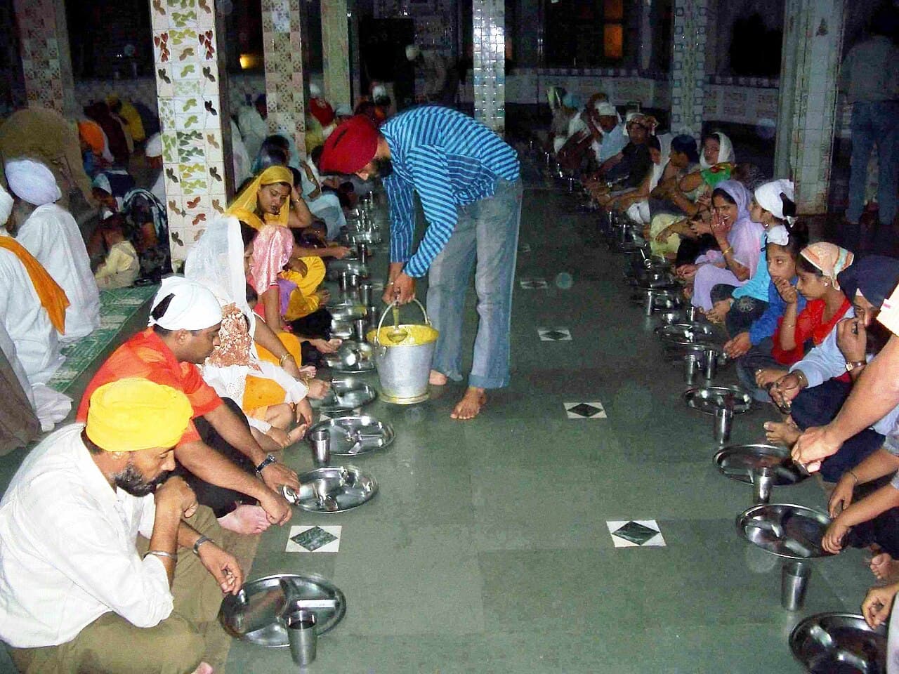 Wierni siedzący przy langarze w gurdwarze, wspólnotowy posiłek sikhijski