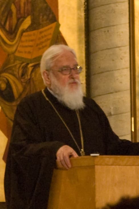 Kallistos Ware, en habit monastique noir, devant un lutrin à Oakland en 2008