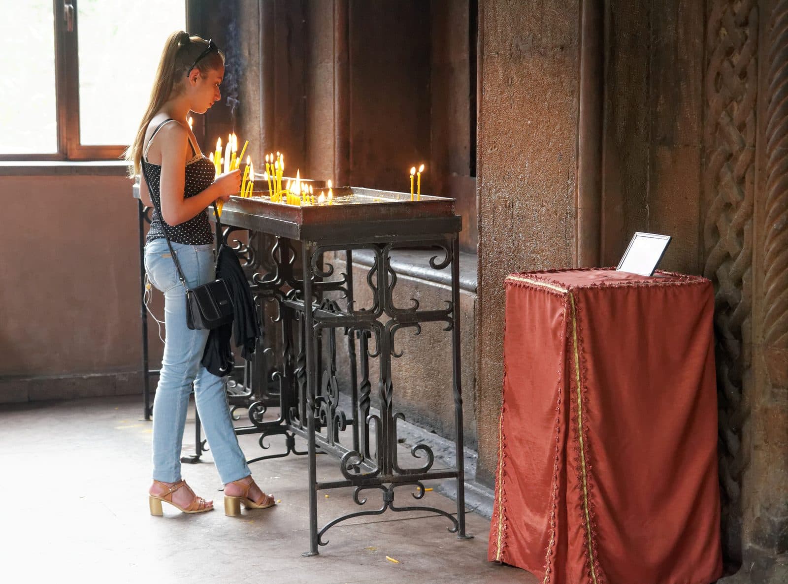 Erivan'daki bir Ermeni kilisesinde adak mumları yakan bir mümin