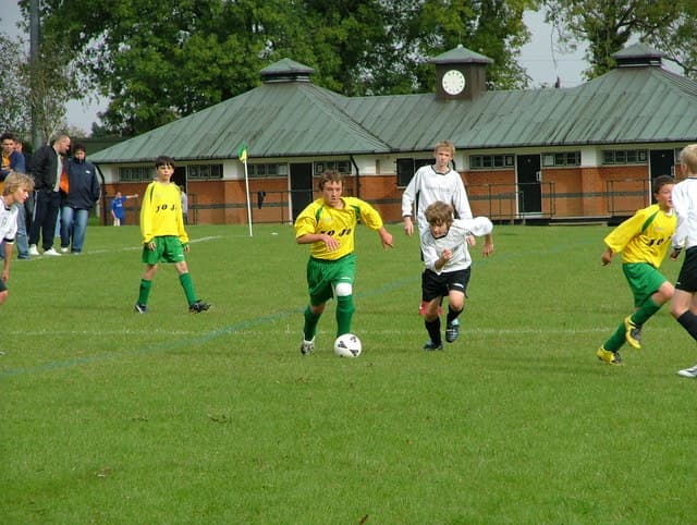 Giovani che giocano a calcio in un campo in Inghilterra