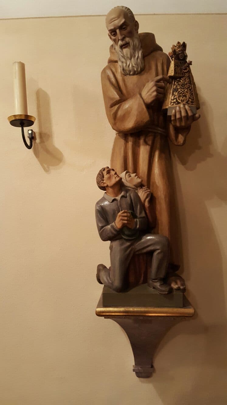 Statue de saint Conrad de Parzham portant une image de la Vierge