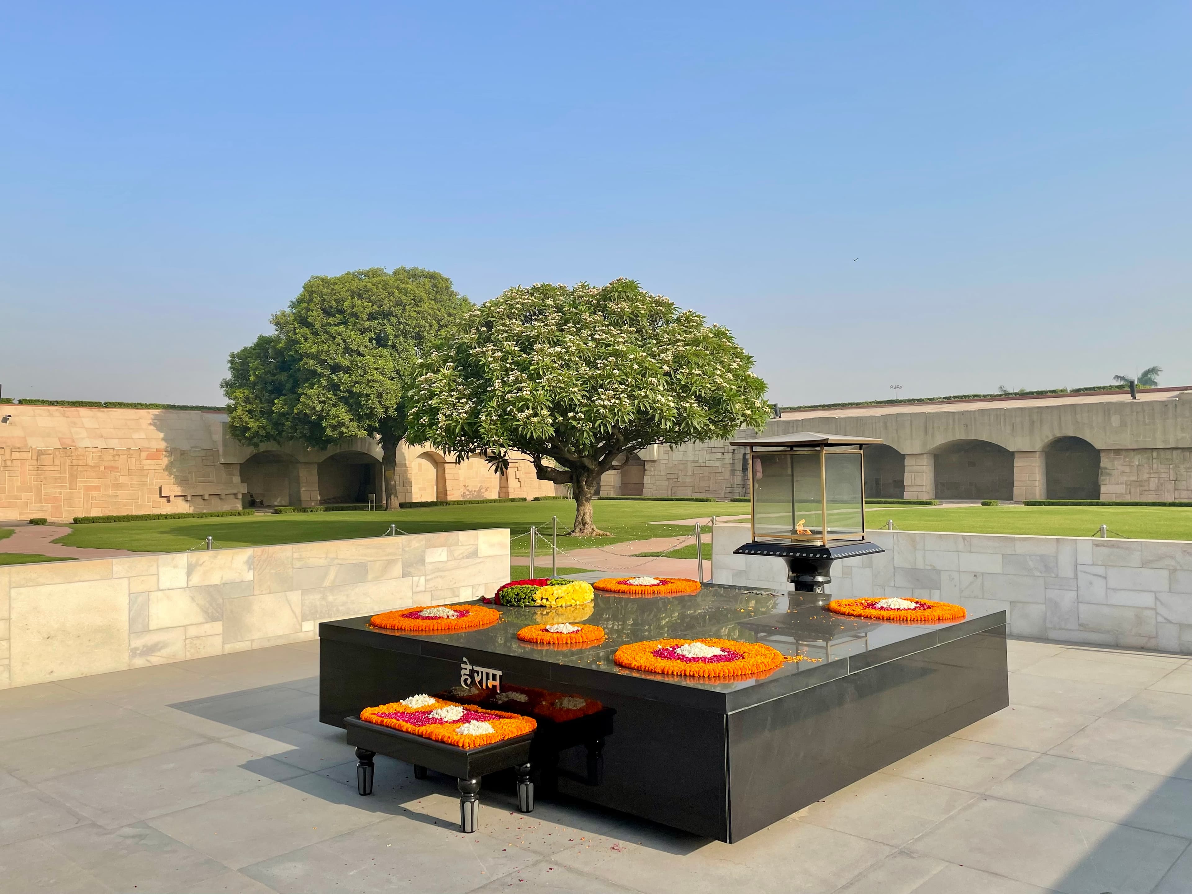 Veduta del memoriale di Gandhi a Raj Ghat con la sua fiamma e le sue corone di fiori