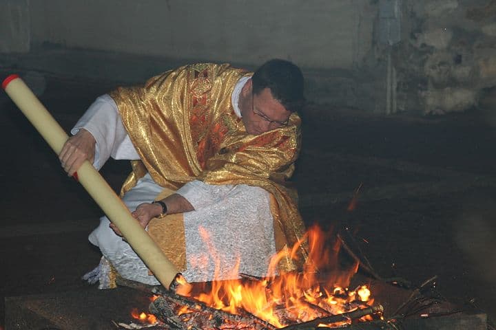 Um sacerdote acende o círio pascal no fogo novo da Vigília Pascal