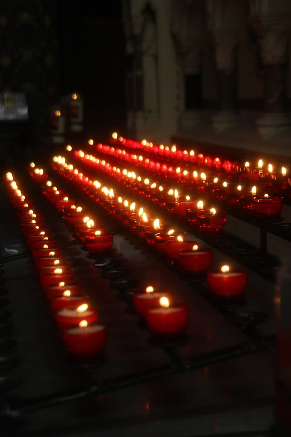 Expositor de círios votivos acesos numa igreja