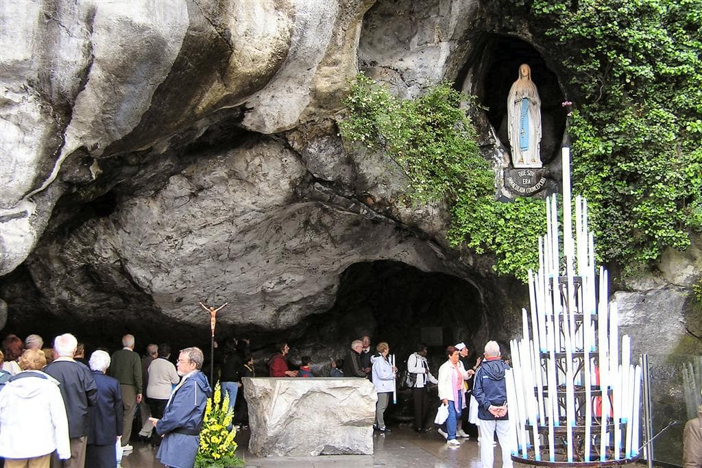 Grotte de Massabielle à Lourdes, statue de Notre-Dame et cierges des pèlerins