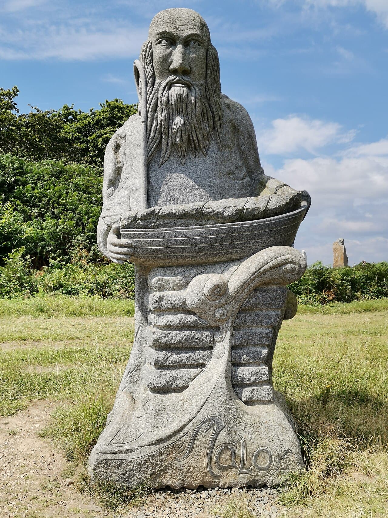 Estatua de granito de san Malo con un barco en la Vallée des Saints