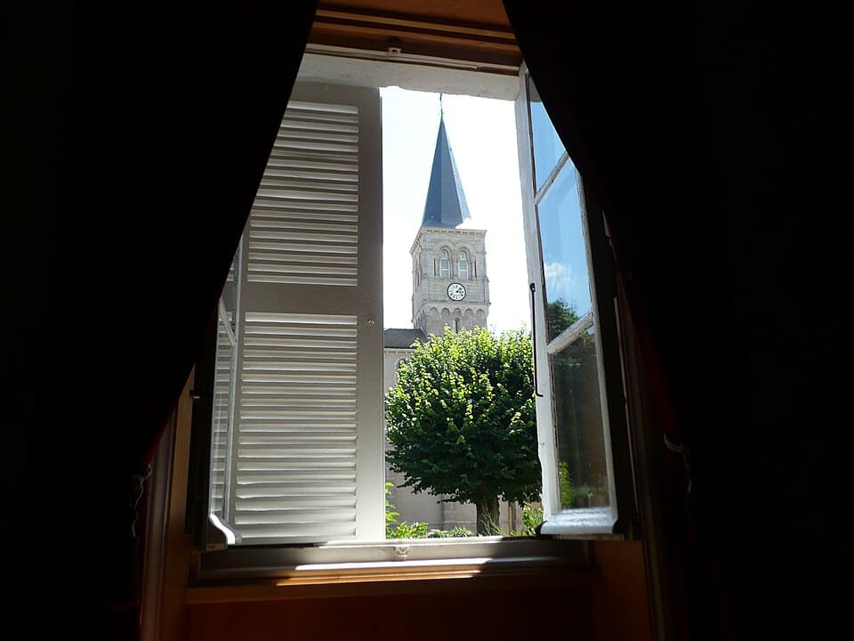 El campanario de Verosvres visto a través de una ventana
