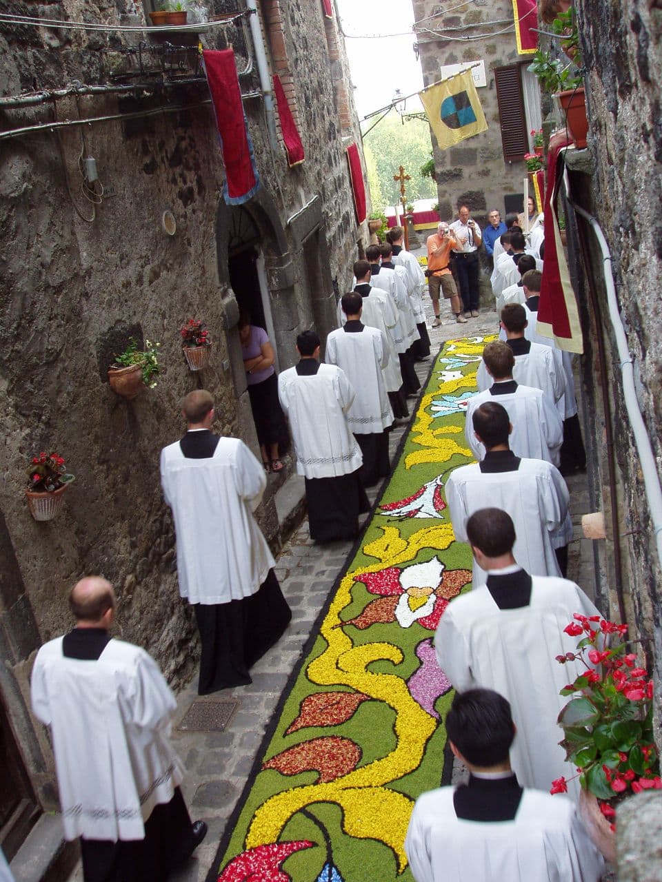 Processione del Corpus Domini lungo un tappeto di fiori in una via di Bolsena