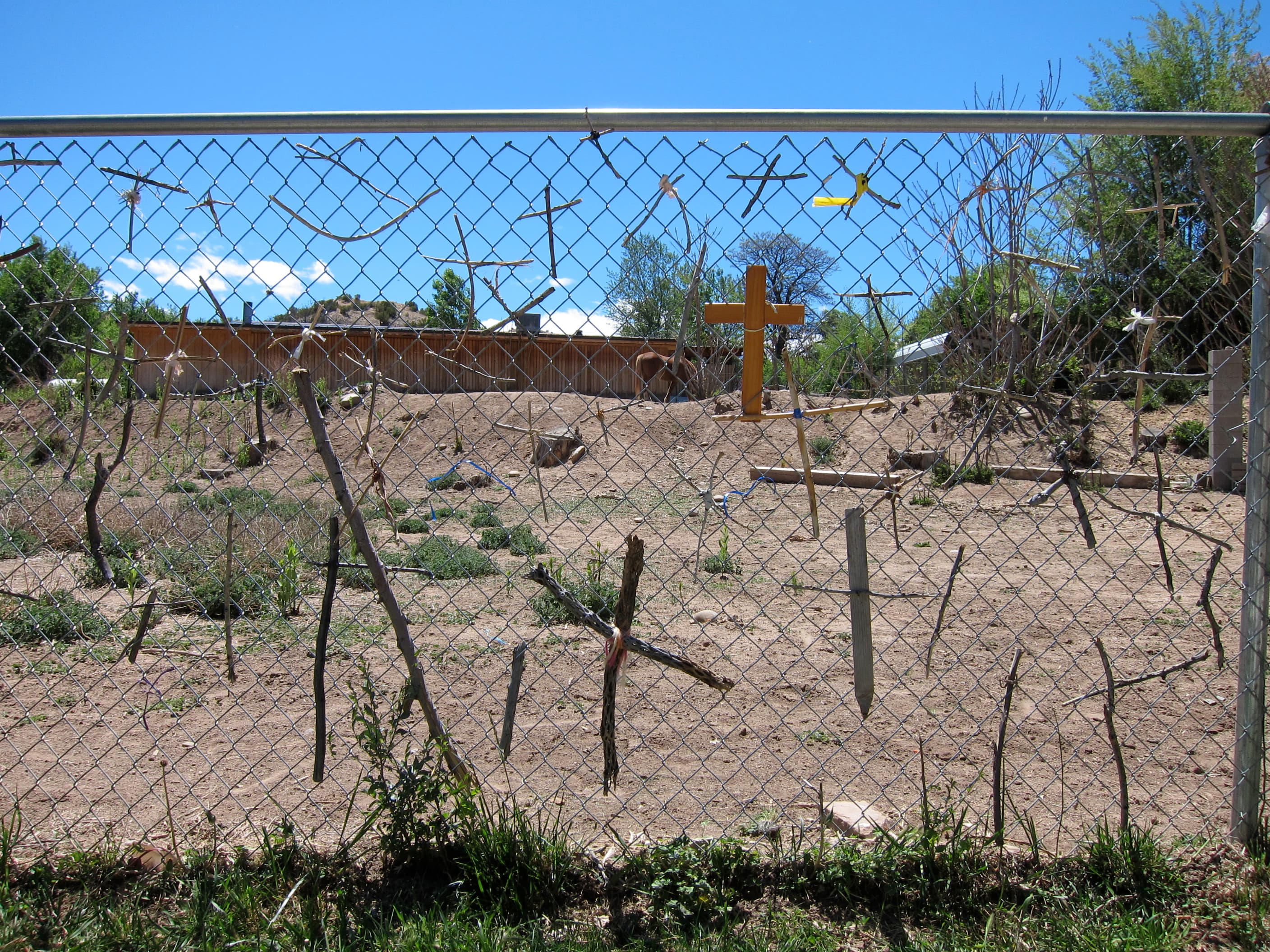 Pequeñas cruces de madera atadas por los peregrinos a una valla del Santuario.