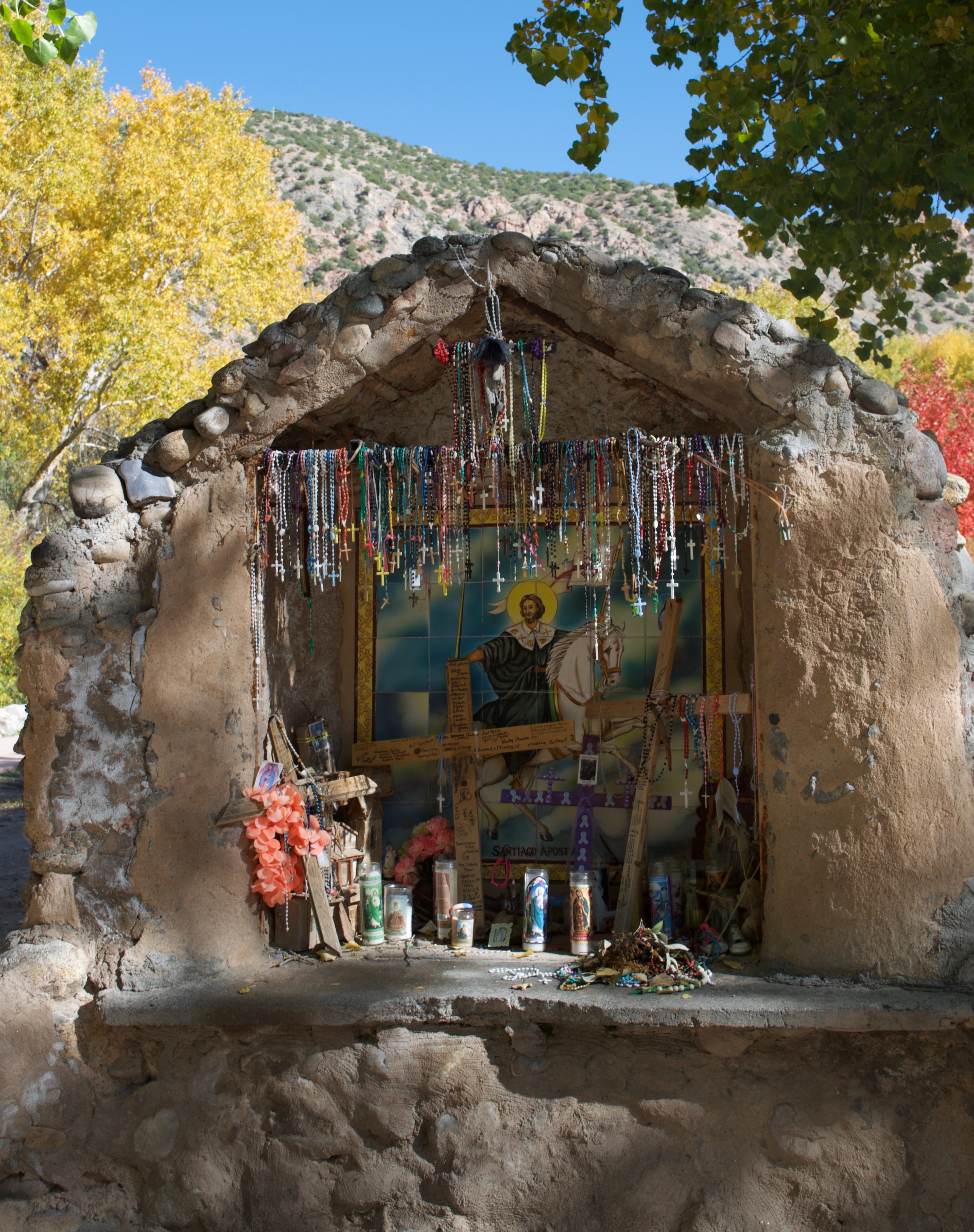 El oratorio exterior del apóstol Santiago, cubierto de rosarios, velas y ofrendas dejadas por los peregrinos.