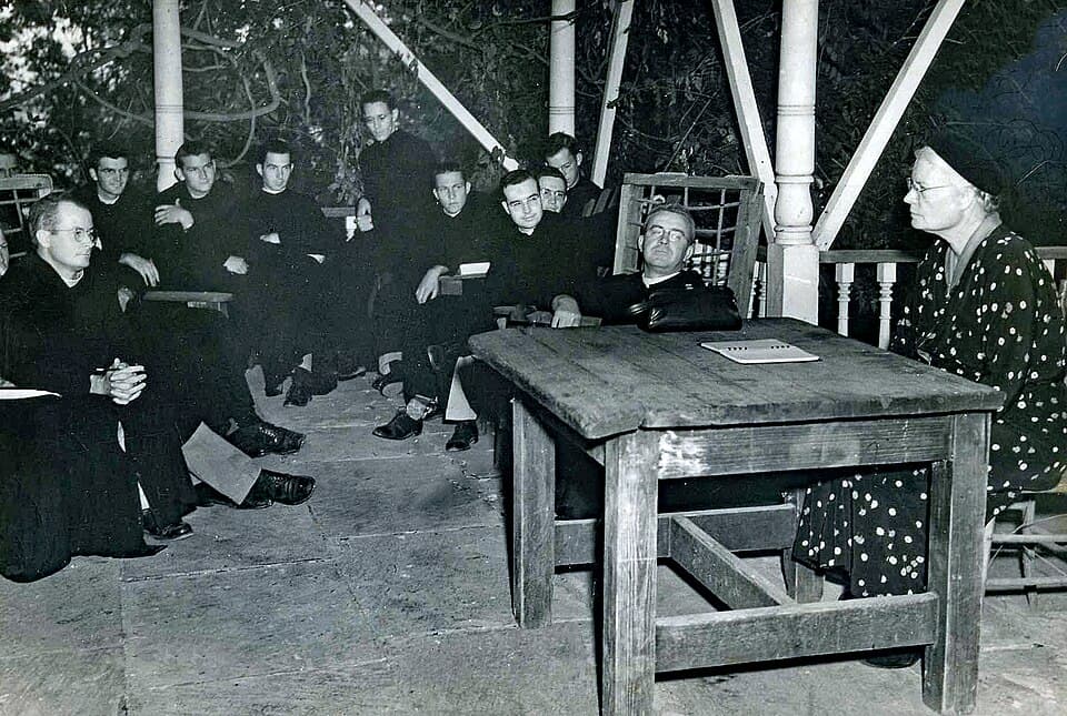 Dorothy Day seated with monks during a visit to Subiaco Abbey