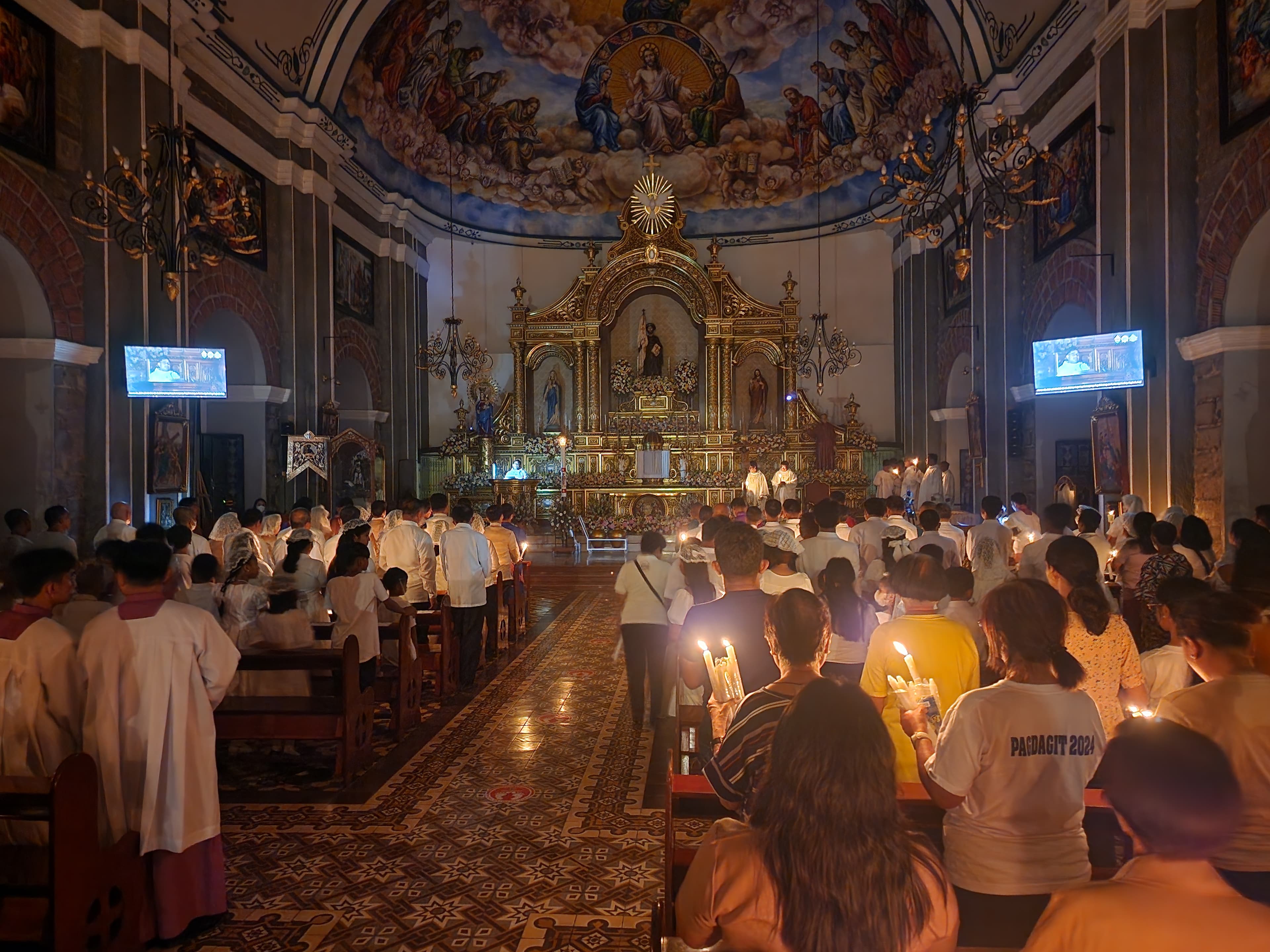 Fiéis segurando os seus círios durante a Vigília pascal em Ibaan