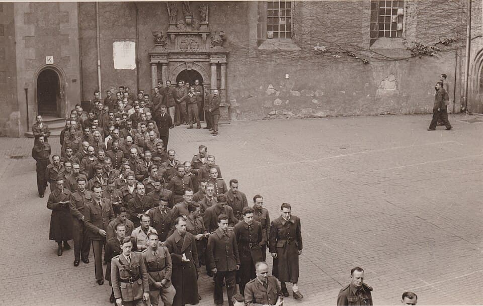 French and Belgian officers in procession in the courtyard of Colditz in June 1943.